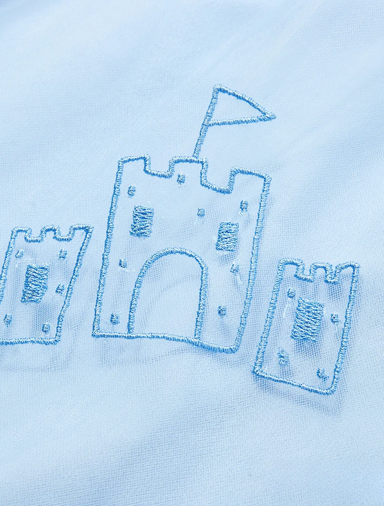 Raised blue outline embroidery of a castle on light blue fabric