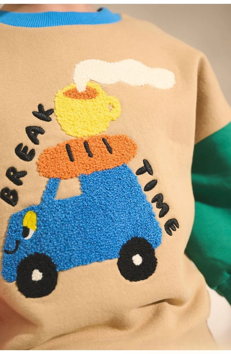 Chenille embroidered truck, bread and teacup with 'Break Time' lettering on a beige sweatshirt