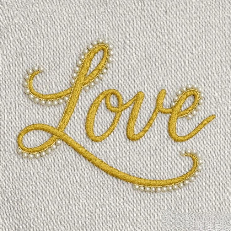 Gold cord script 'Love' edged with pearl beads on light grey fabric