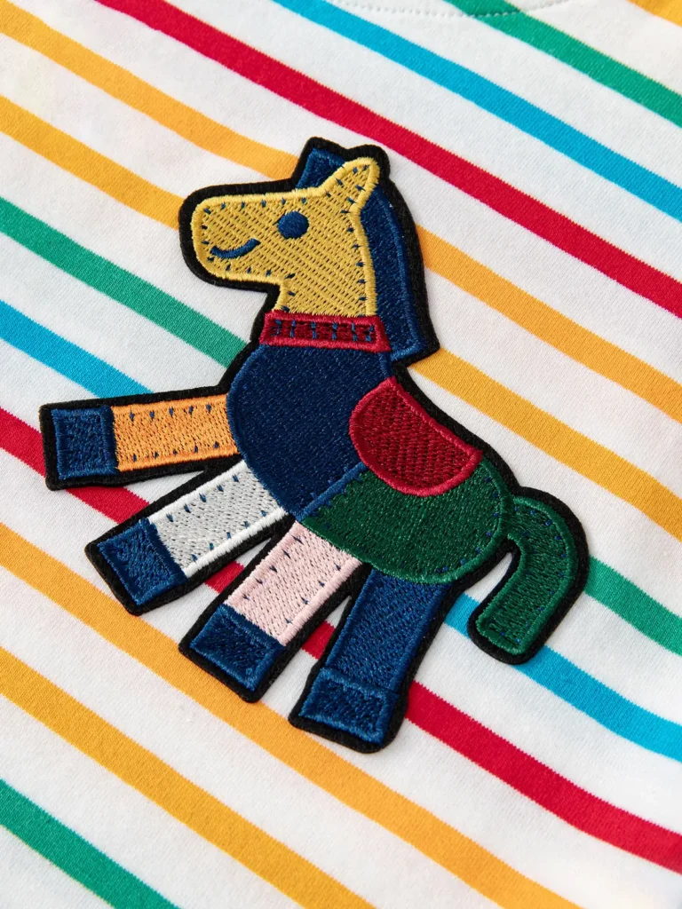 Embroidered patchwork horse patch on a rainbow striped kids top