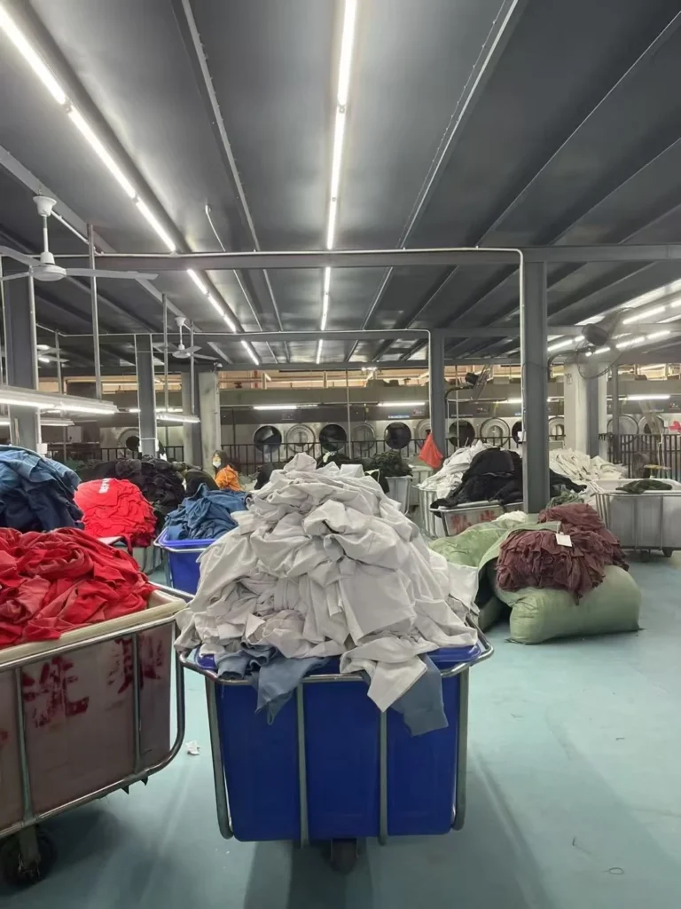 Garment washing plant floor with carts of T-shirts awaiting processing