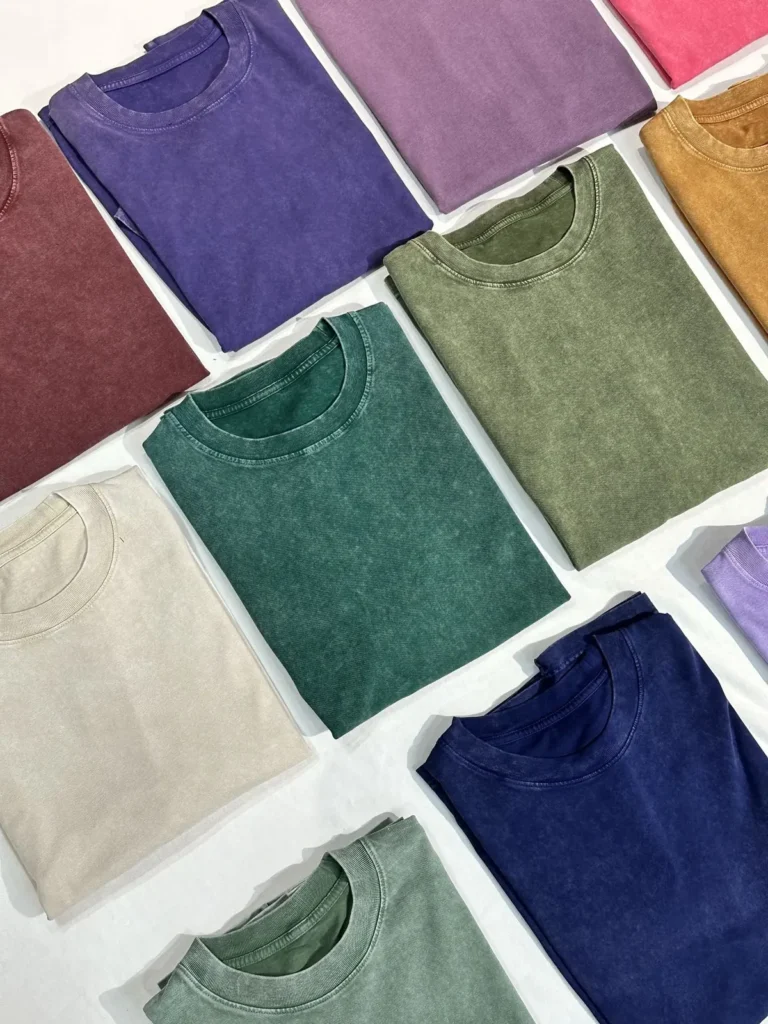 Flat lay of garment-washed T-shirts in purple, green, burgundy, cream and navy