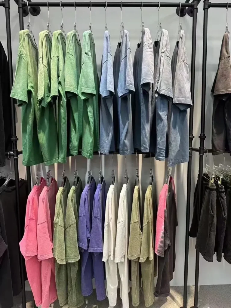 Rack of washed T-shirts and shorts in green, blue, pink and grey tones