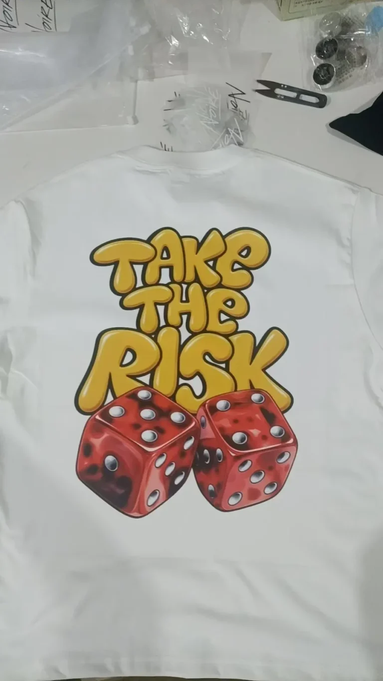 'Take The Risk' lettering and red dice print on a white T-shirt