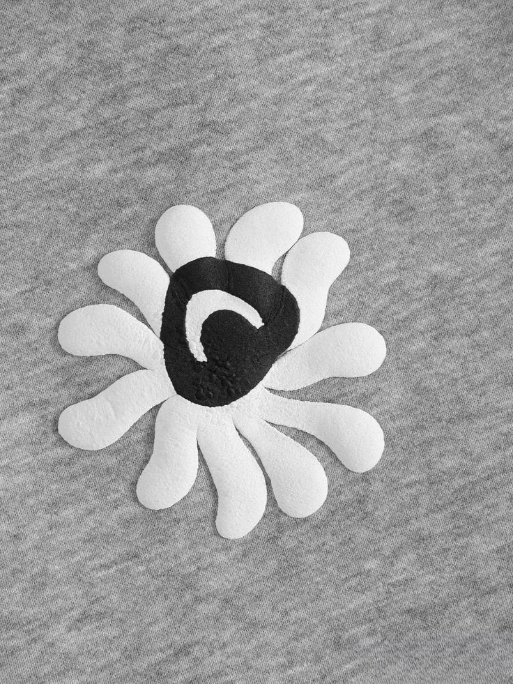 White puff-printed flower with black centre on grey marl fabric